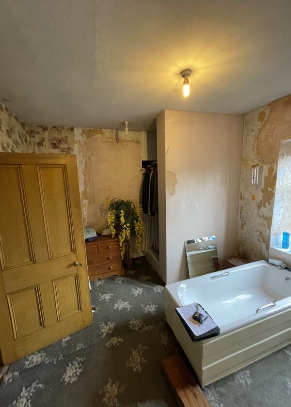 Before photo - Unfinished large bathroom with a dated ad bulky bath